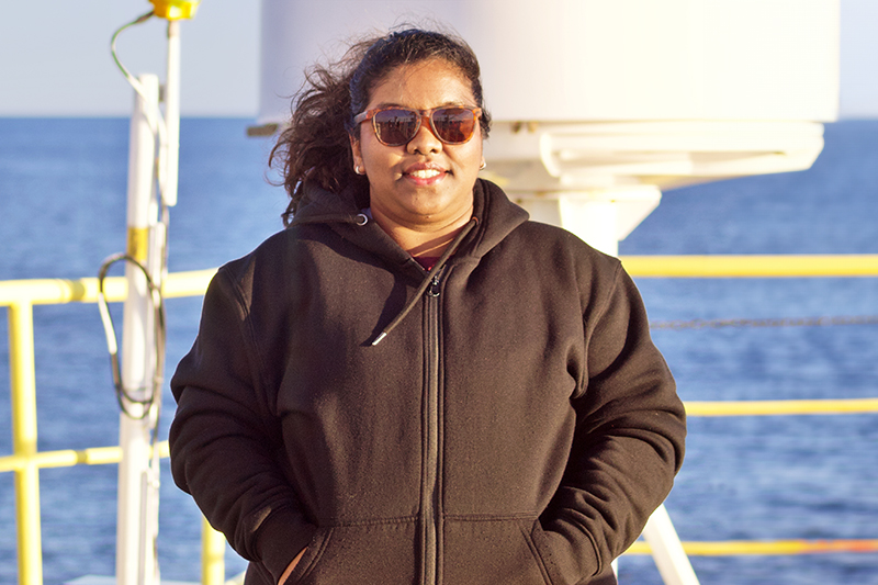 Kapuge is pictured aboard the JOIDES Resolution with the Fram Strait and Svalbard in the background. Kapuge is pictured aboard the JOIDES Resolution with the Fram Strait and Svalbard in the background.